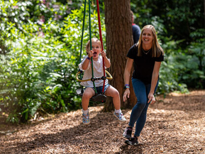 A mother and child play on the Twiggle Whizzers at BeWILDerwood