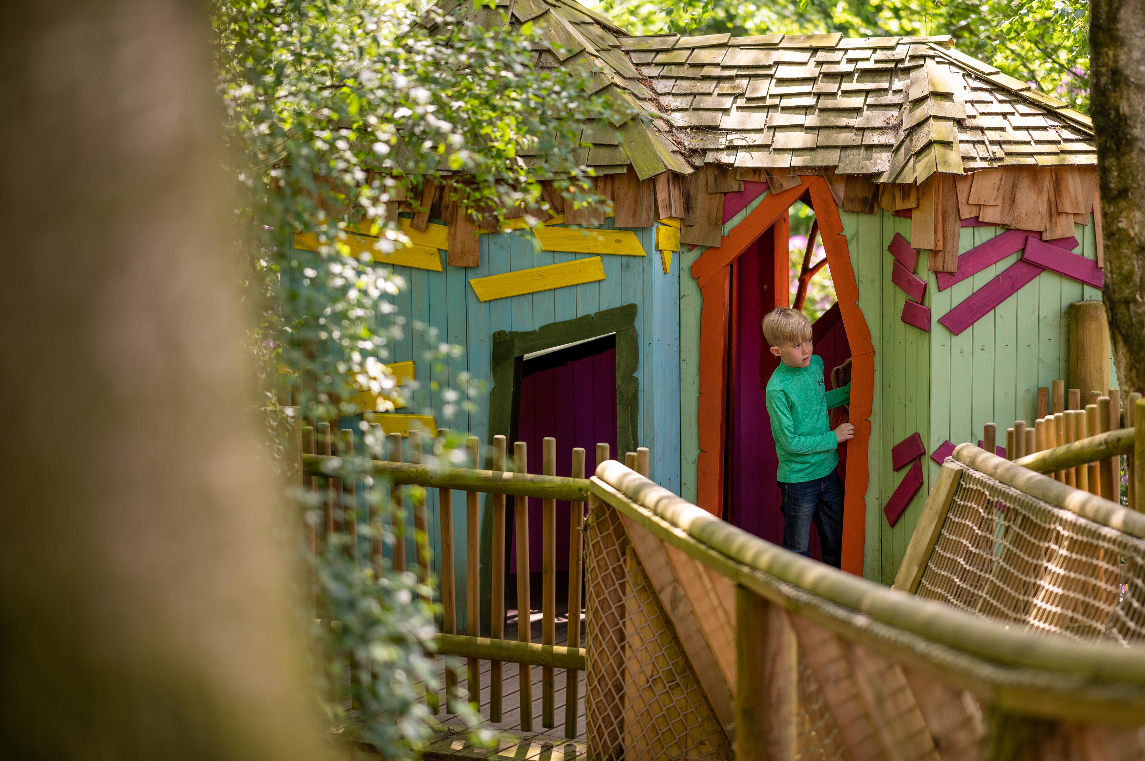 A boy explores BeWILDerville, a colourful wooden treehouse in BeWILDerwood Cheshire