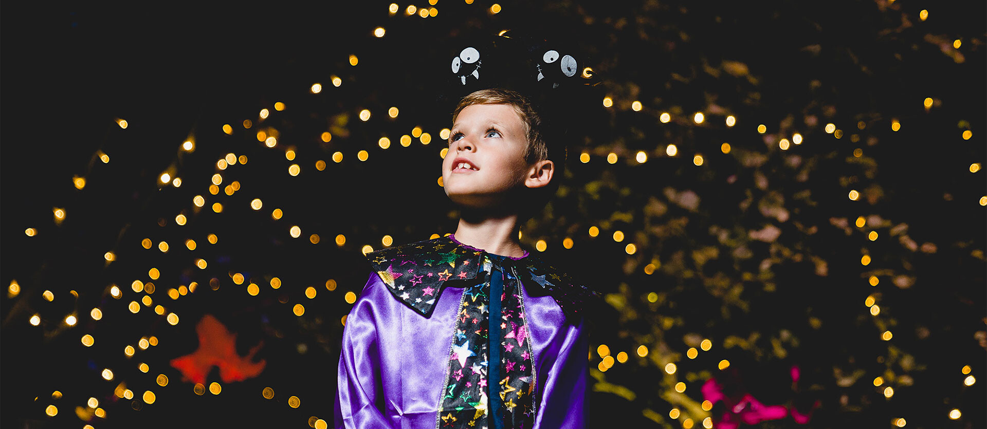 A child stands against a light display at BeWILDerwood