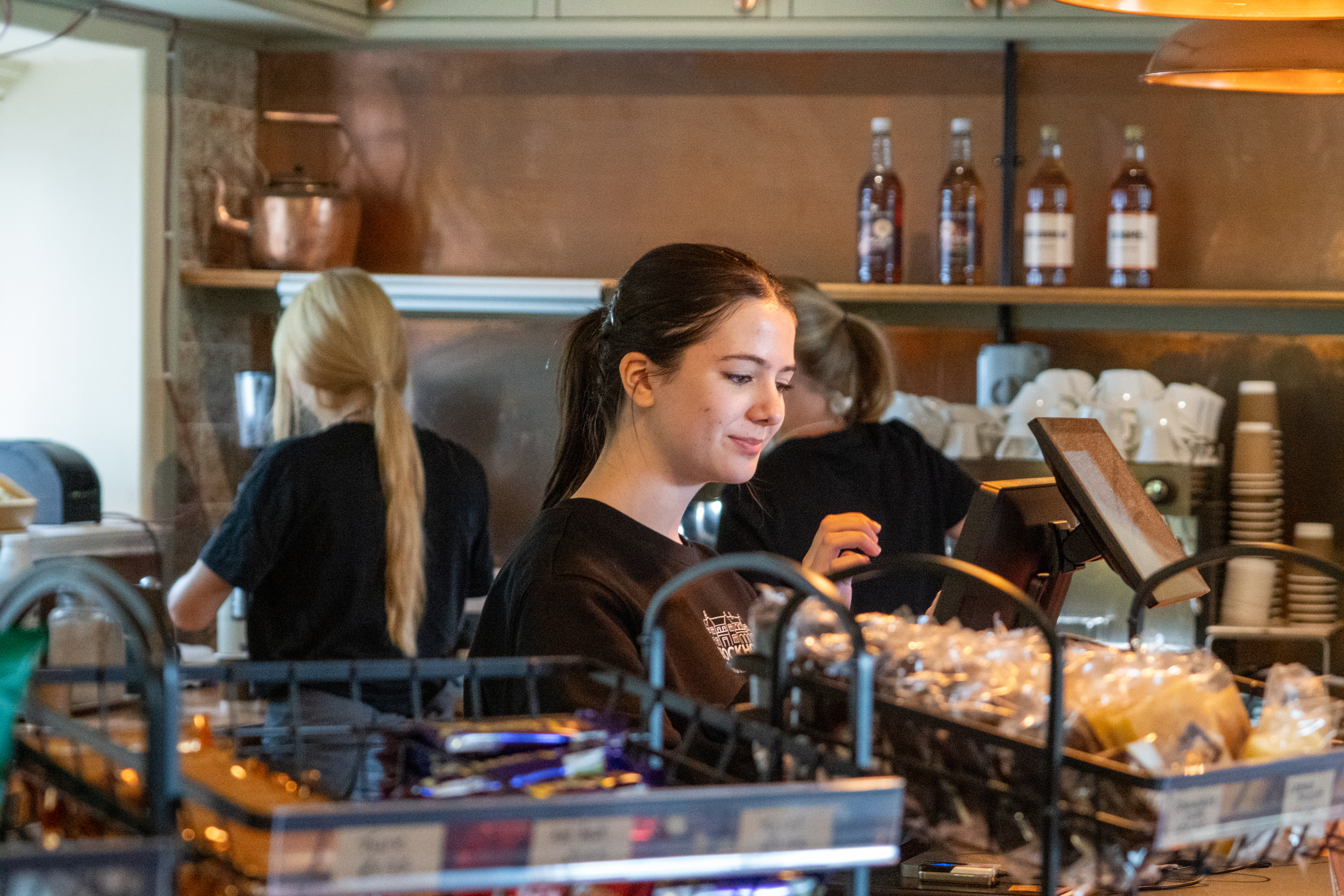 A cafe staff member working behind the till.