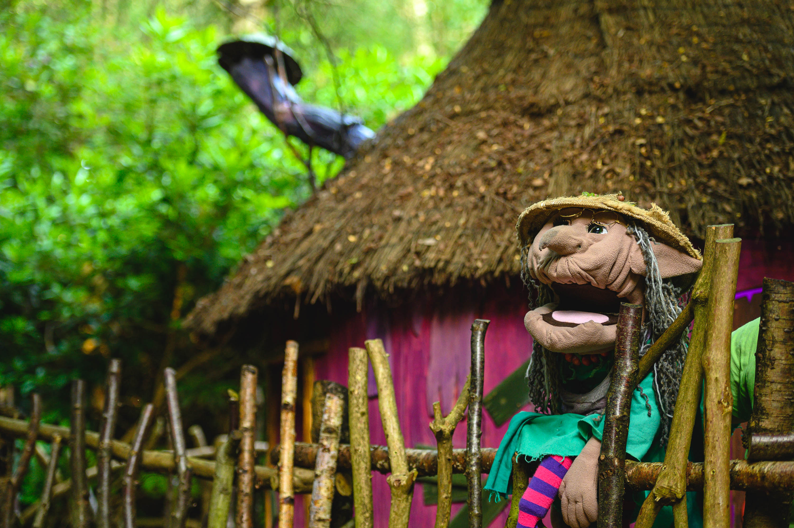Witch puppet outside house structure at bewilderwood