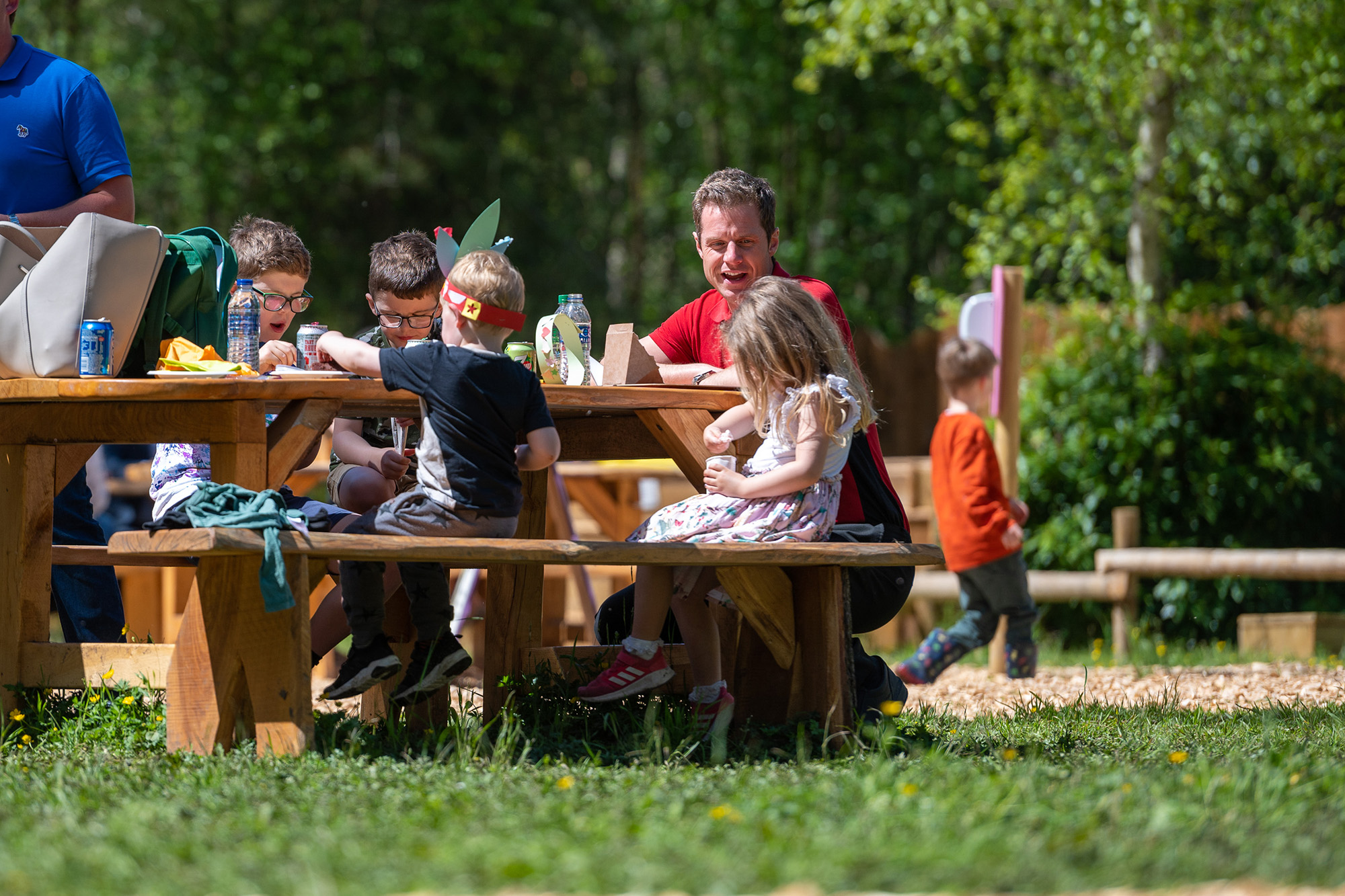 Family eating on a picnic bench at bewilderwood