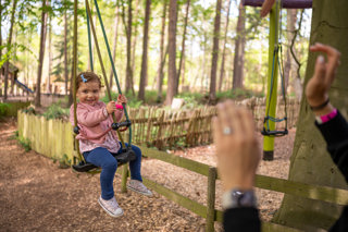 Toddler sat on a toddler zipline at BeWILDerwood