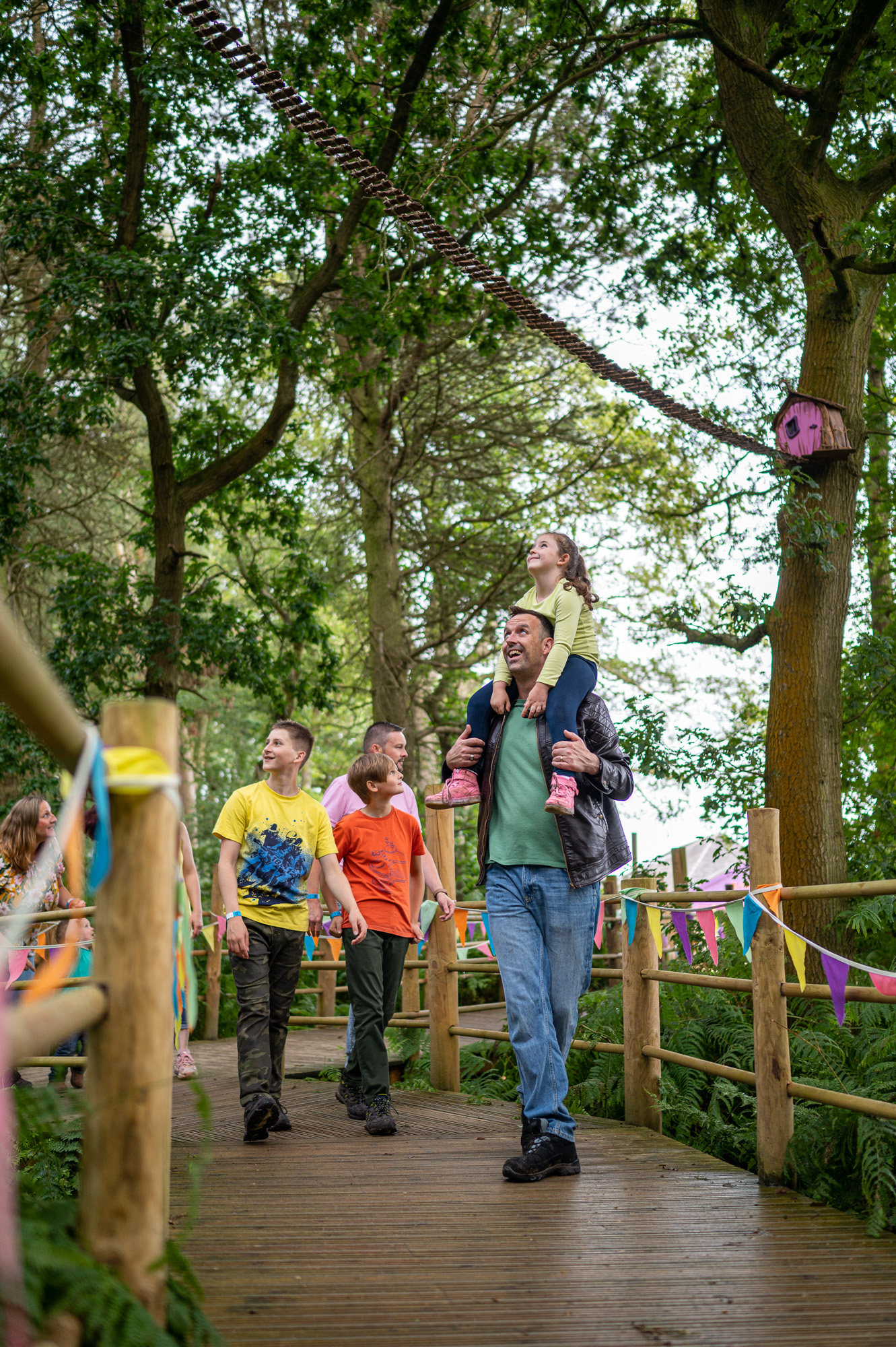 Family walking down wooden trail at bewilderwood
