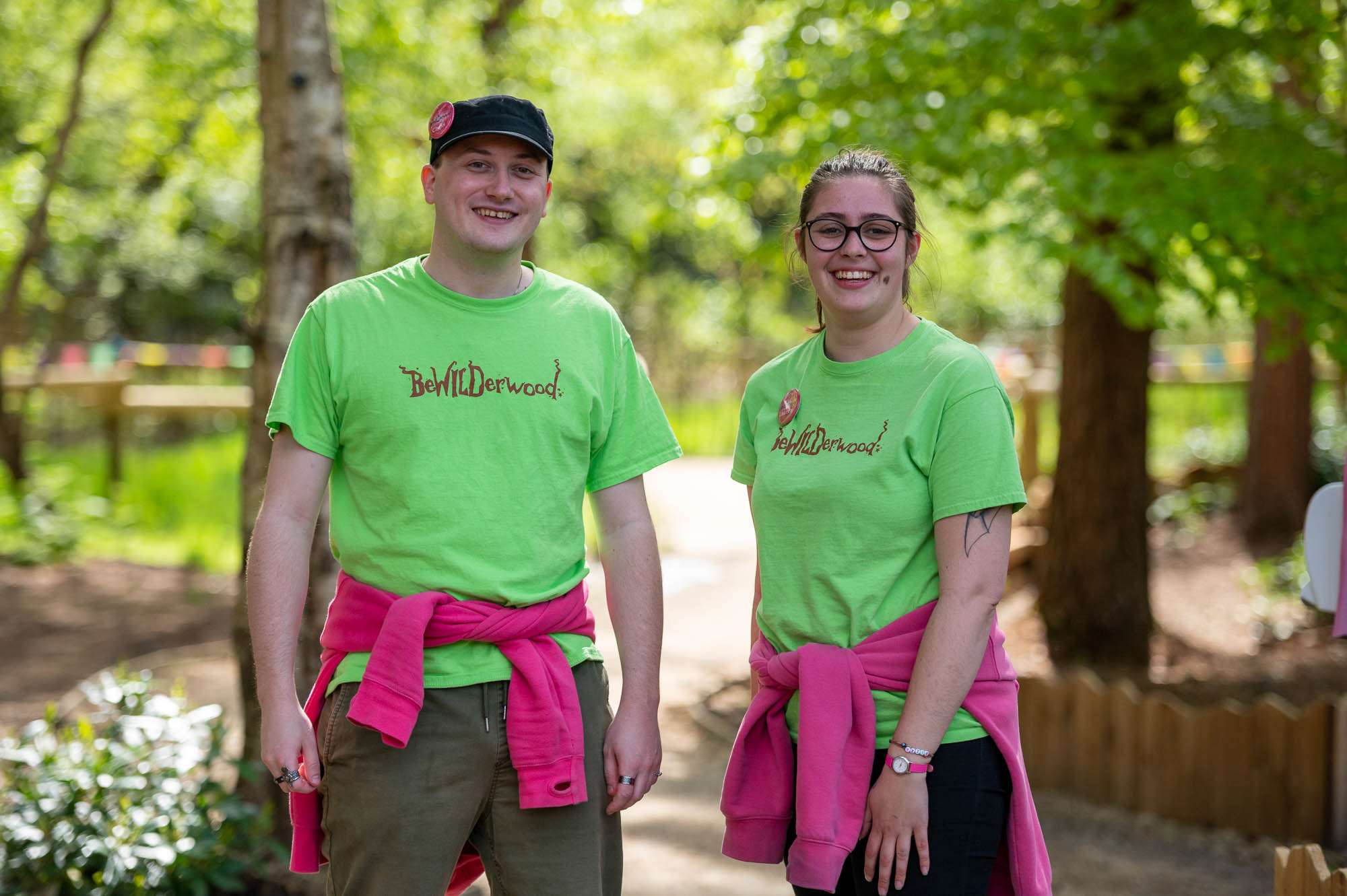 Two members of staff standing in the woods