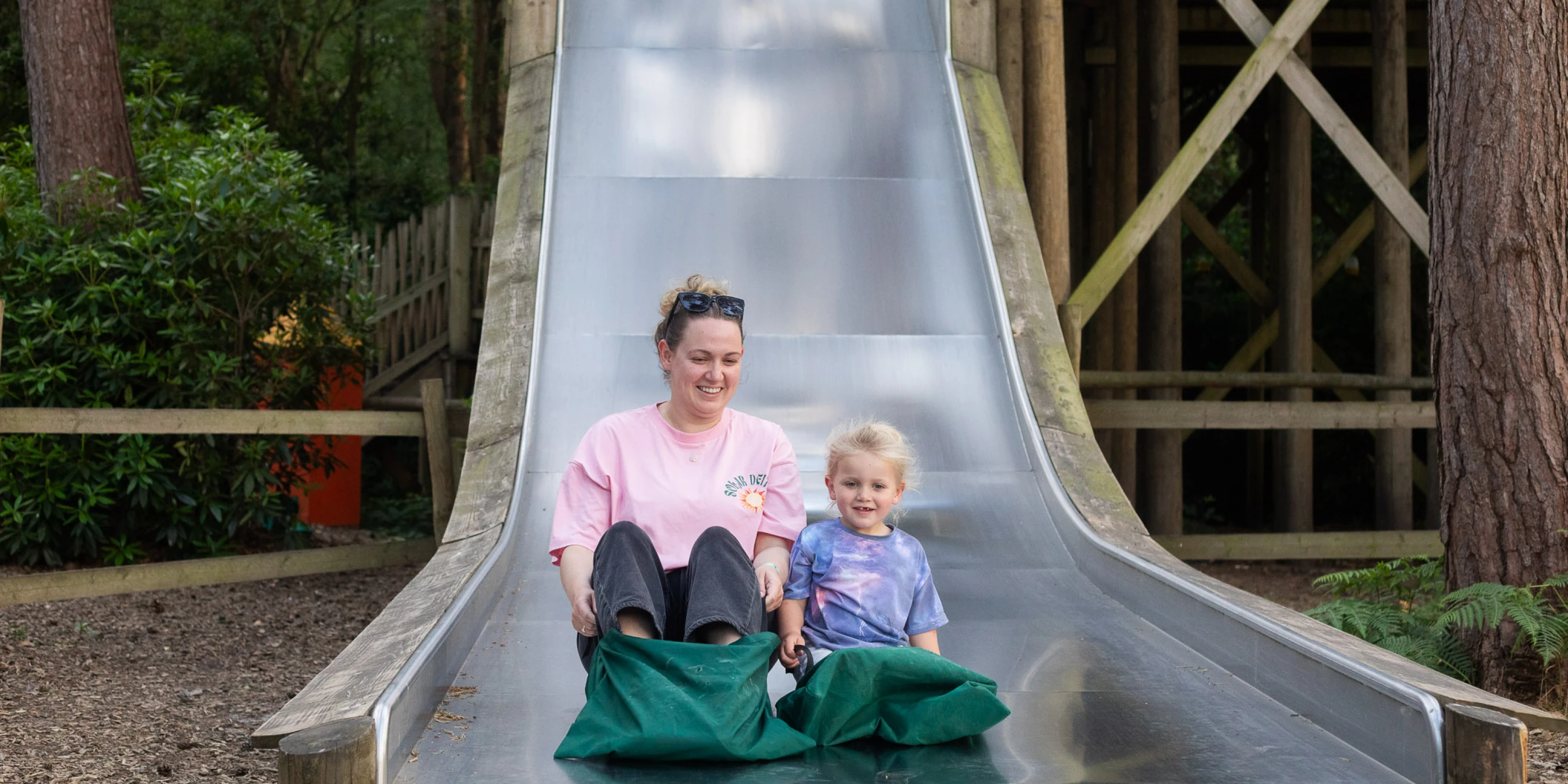 Mum and daughter going down a slide at Bewilderwood