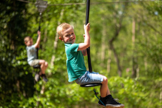 Boy playing on zip wire at bewilderwood