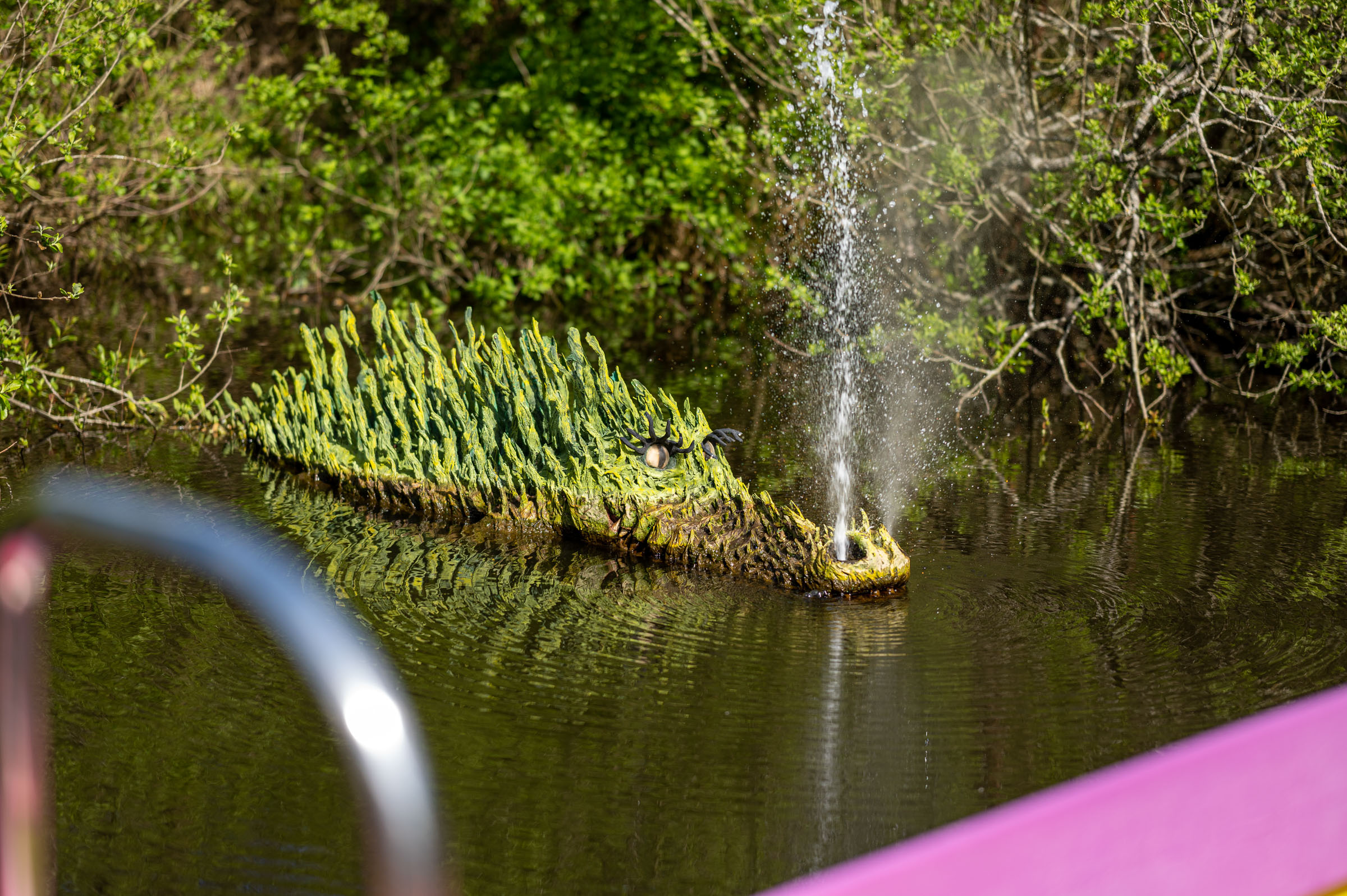 Green Crocklebog from Bewilderwood on a lake with water squirting out of her nose
