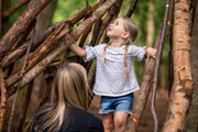 Mum and daughter building a den out of sticks at bewilderwood