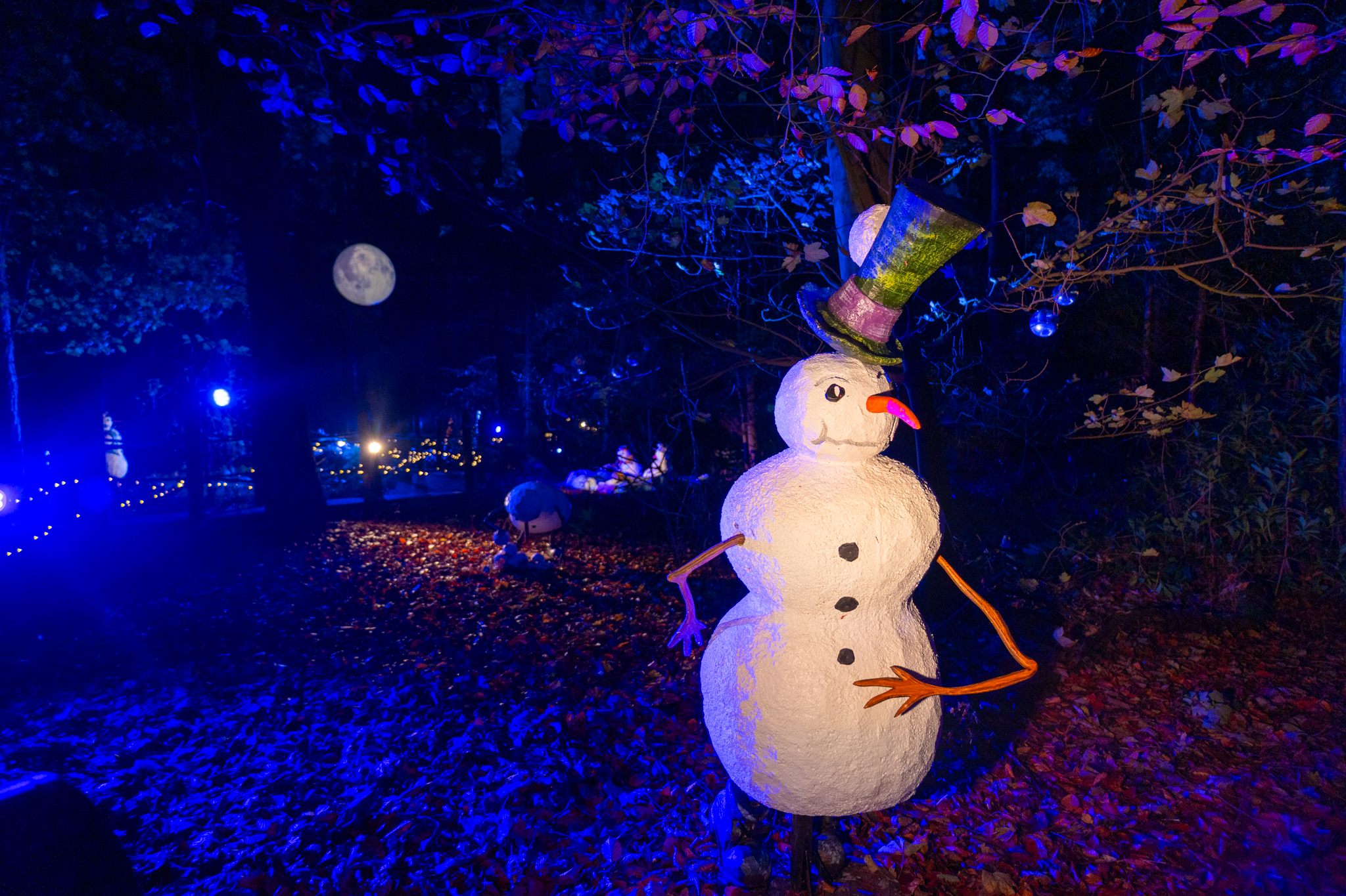 Snowman in the dark in woodland, with moon in background